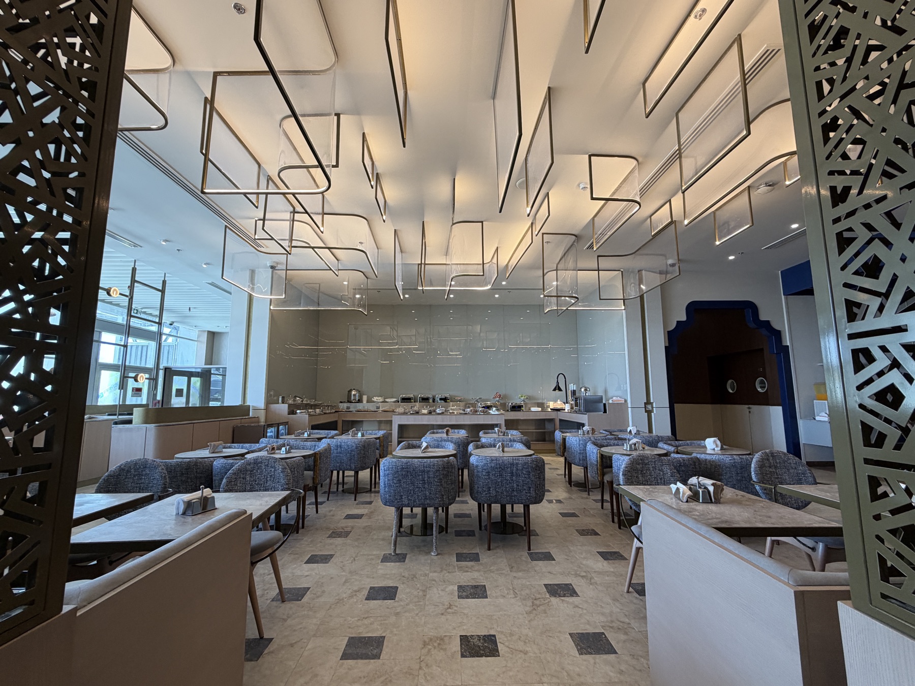 Dining hall beneath a sculptural brass ceiling